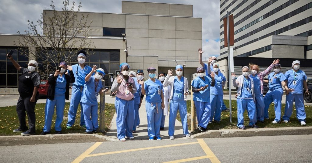SHN health care workers wave on the curb outside the hospital